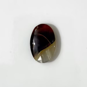 فص عقيق يماني ملون طبيعي مصقول بيضاوي يظهر بنصف بني معتم ونصف زجاجي شفاف بشكل رأسي